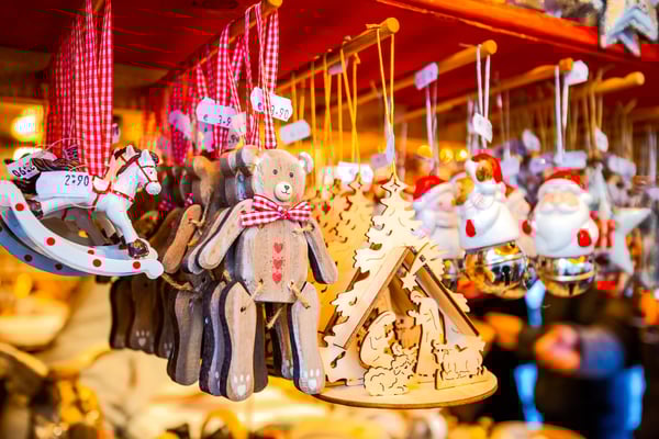 Gros plan sur des décorations de Noël artisanales en bois suspendues sur un stand de marché