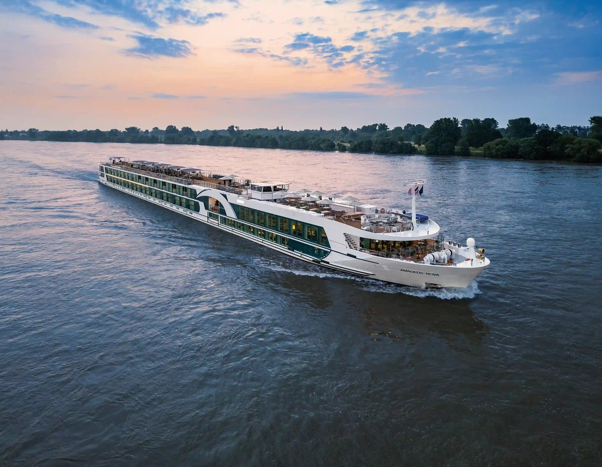 Bateau de croisiere fluviale MS Amadeus Nova naviguant sur le Danube au coucher du soleil.