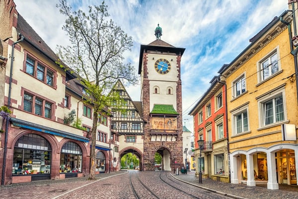 Historisches Stadttor in Freiburg mit Strassenbahn und bunten Häusern