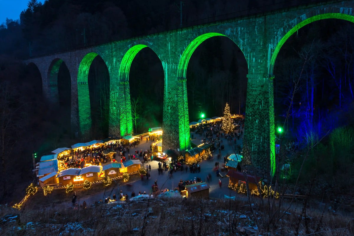 Beleuchteter Weihnachtsmarkt in der Ravenna-Schlucht unter einem Viadukt
