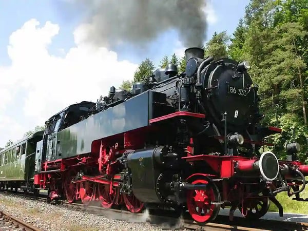 Historische Dampflok der Sauschwänzlebahn fährt durch eine grüne Landschaft