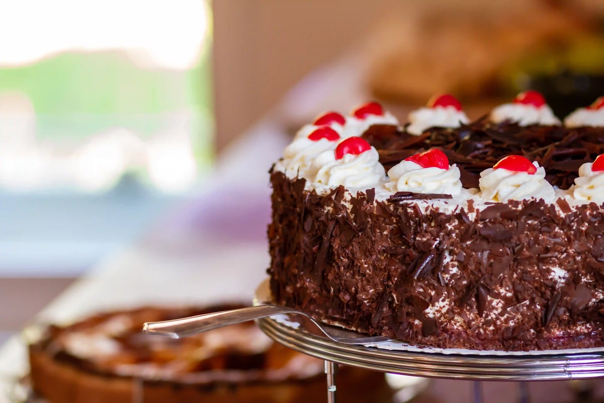 Schwarzwälder Kirschtorte mit Sahne, Schokolade und Kirschen auf einer Tortenplatte
