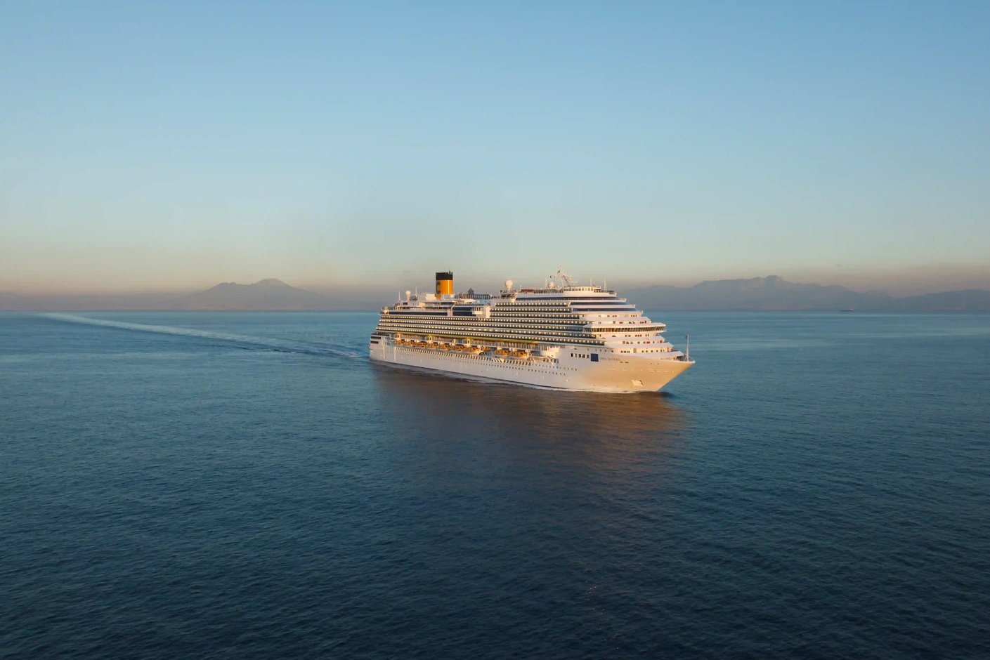 Costa Diadema bei Sonnenuntergang auf offenem Meer mit goldenem Licht auf der Wasseroberfläche