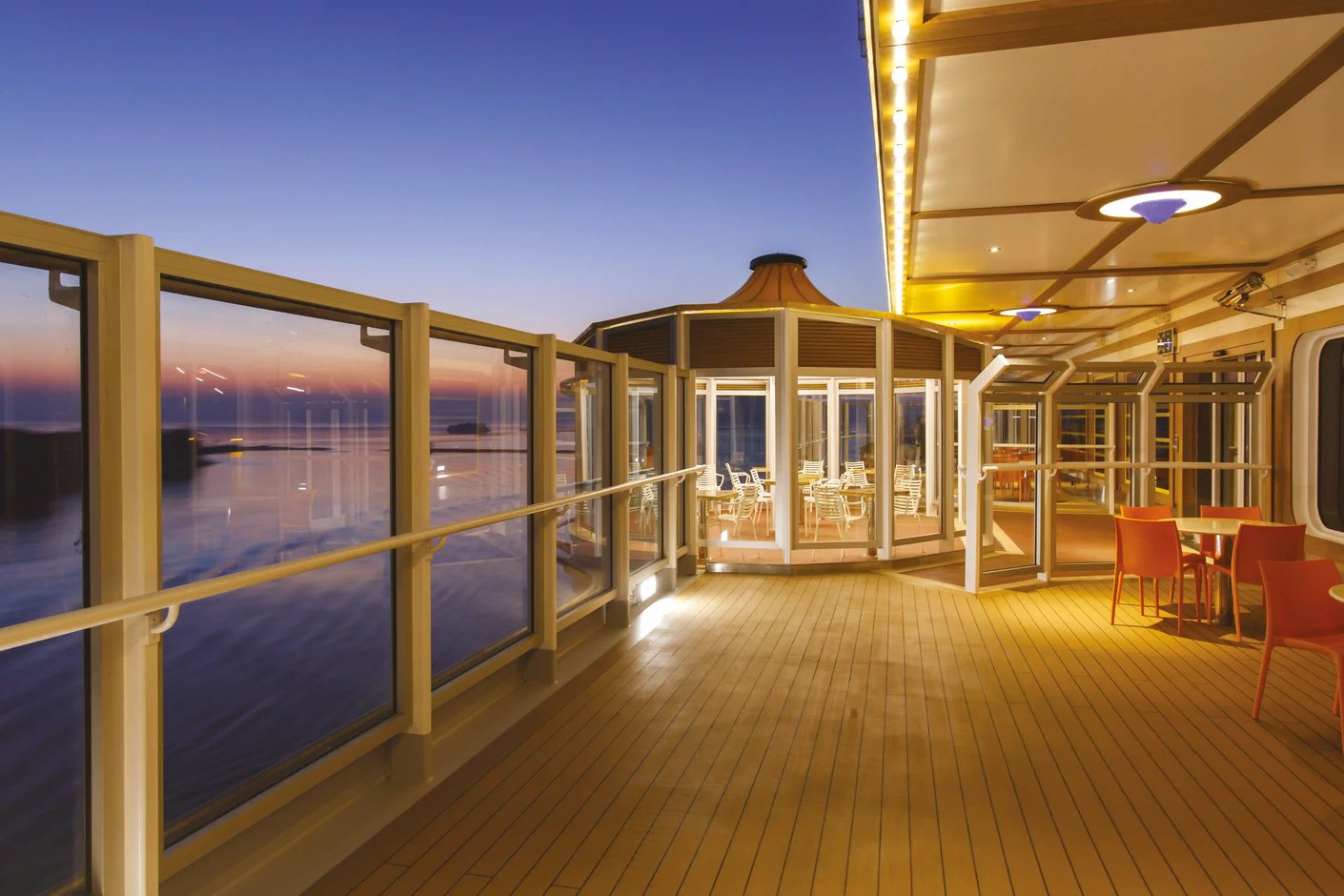 Aussenbereich auf der Costa Diadema mit Glasfronten und Sitzplätzen bei Dämmerung