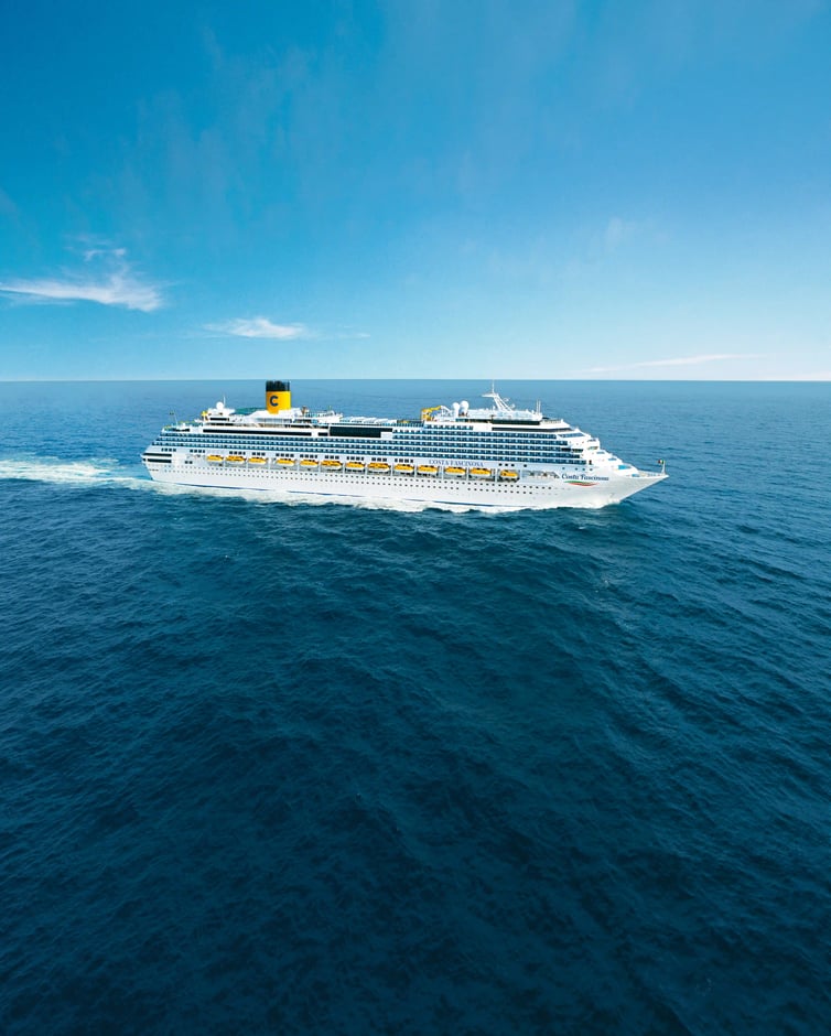 Großes Kreuzfahrtschiff Costa Diadema fährt bei ruhiger See unter blauem Himmel, Seitenansicht mit mehreren Decks und gelben Rettungsbooten