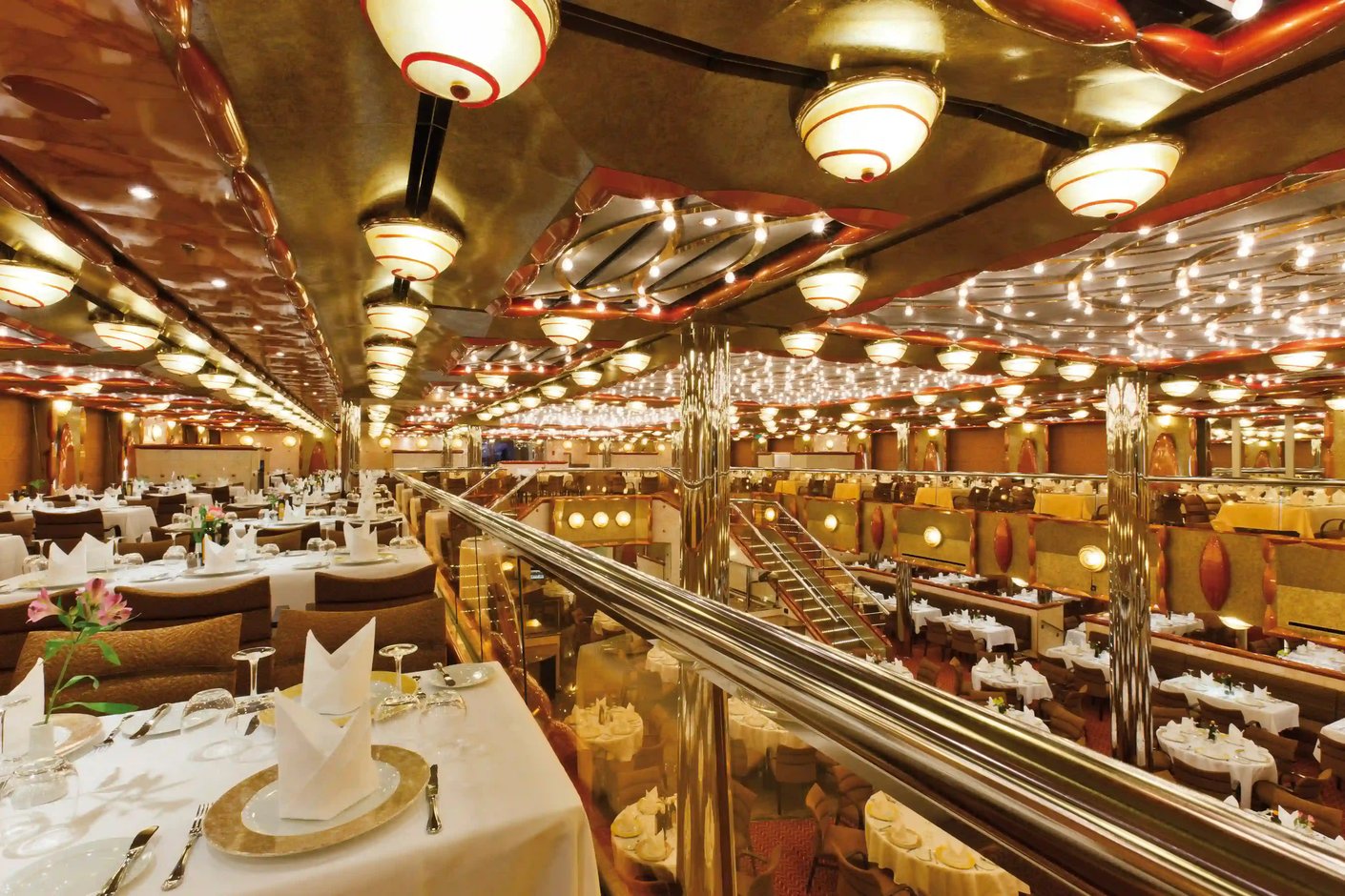 Grosses Restaurant auf Kreuzfahrtschiff mit gedeckten Tischen und Galerieebenen