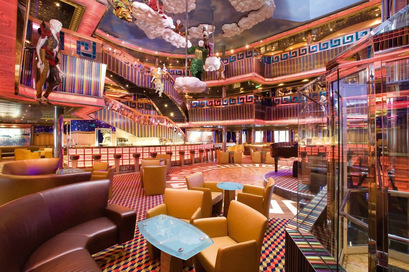 Grosses Atrium mit Bar, Sitzgruppen, mehreren Decks und dekorativen Figuren