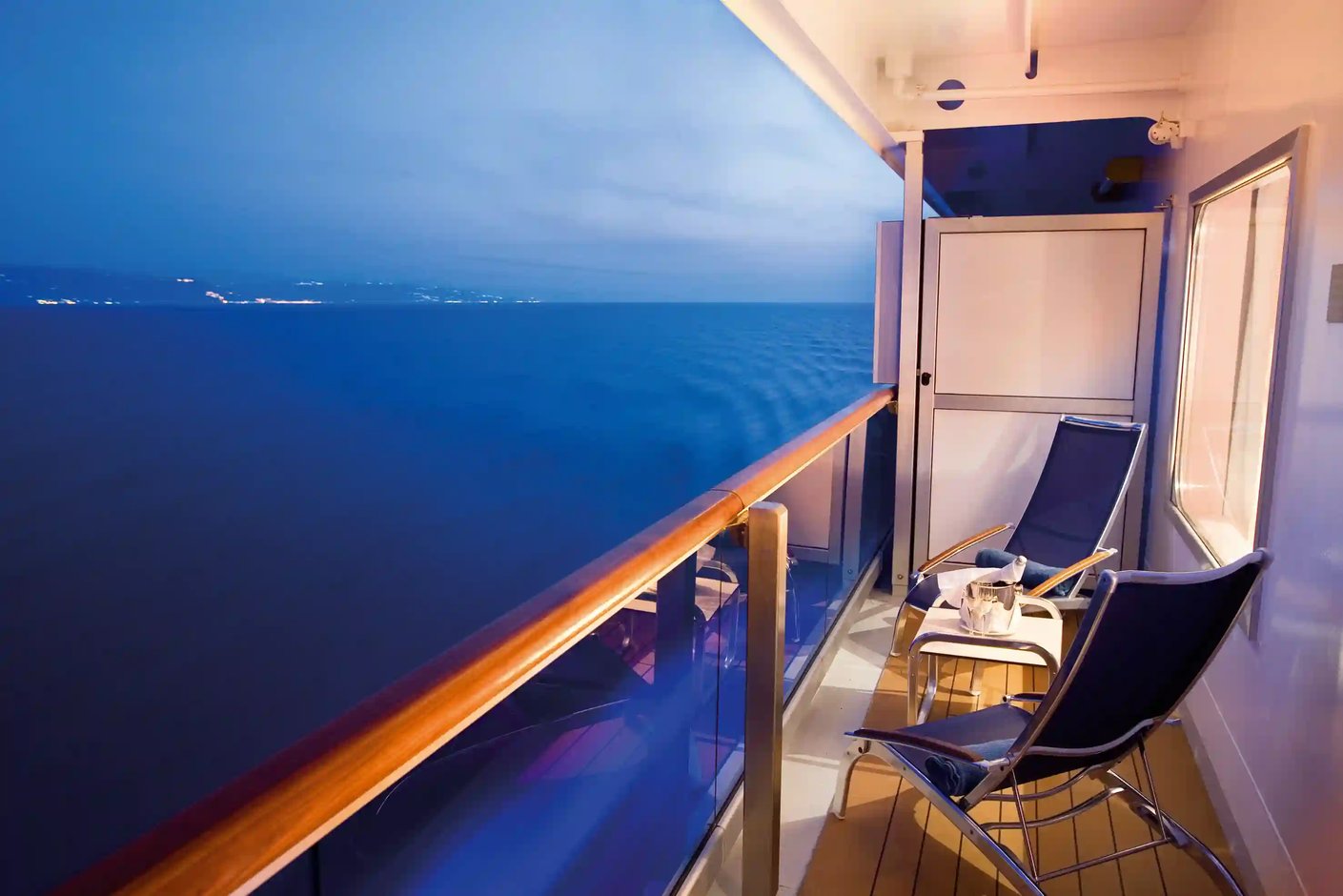 Balkon mit zwei Liegestühlen und Blick auf das Meer