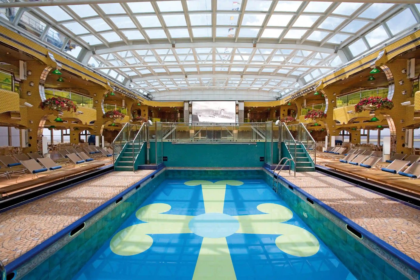 Poolbereich mit Treppen, Liegestühlen und Glasdach