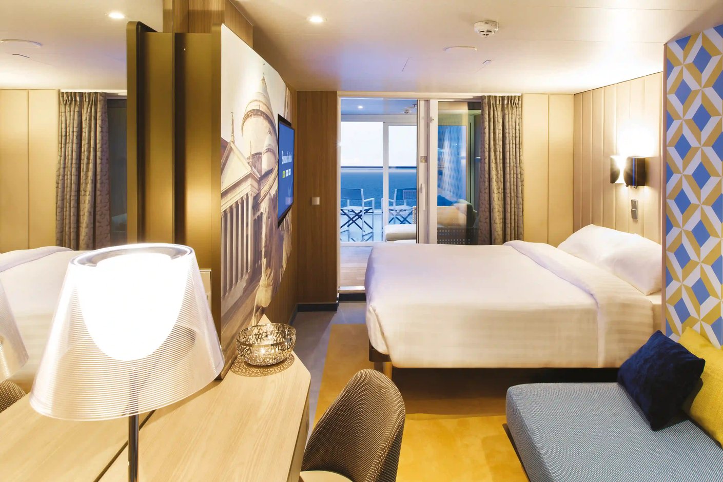 Moderne Balkonkabine der Costa Smeralda mit Doppelbett, Sitzsofa und Blick auf das Meer