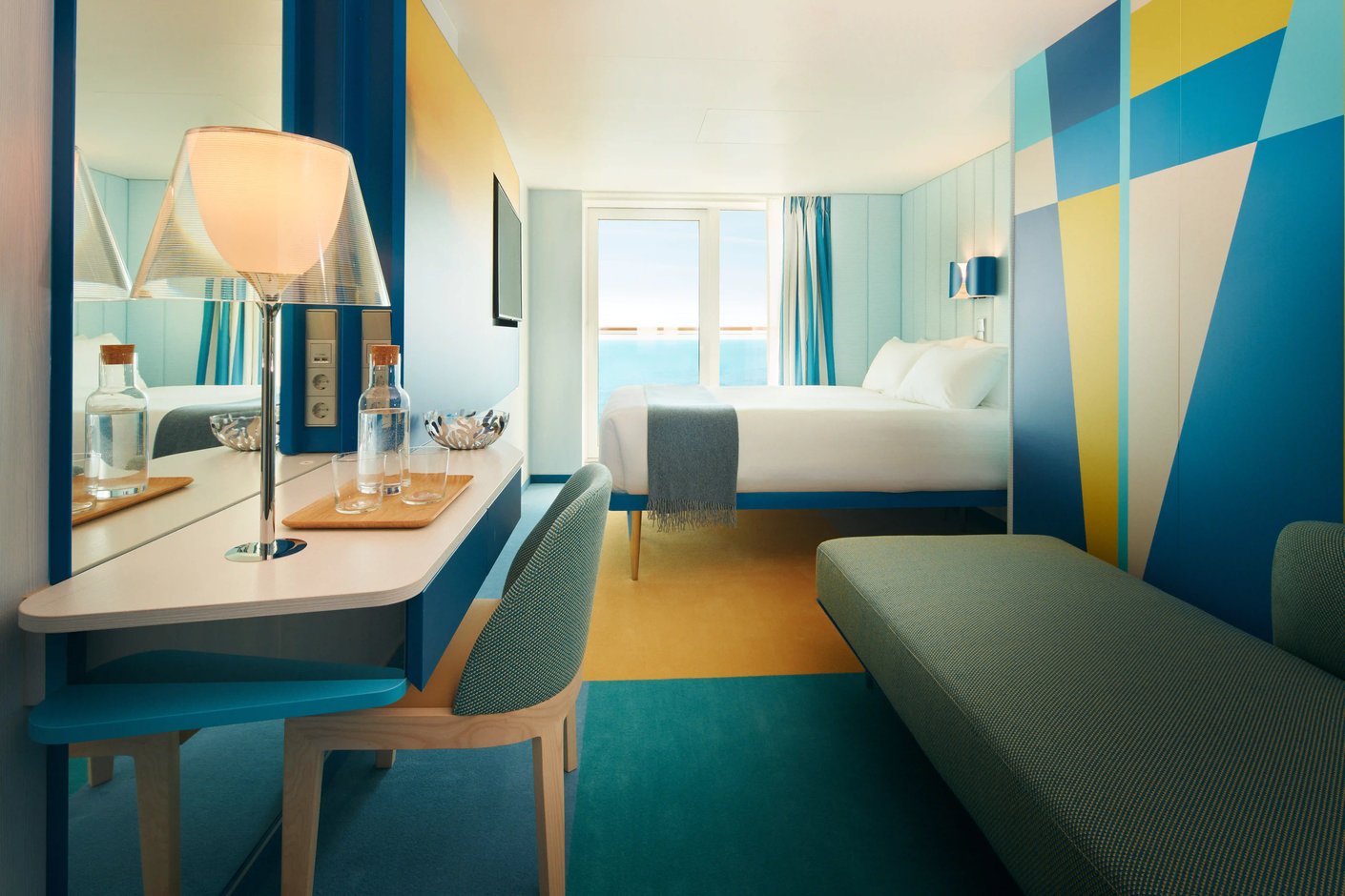 Cabine avec balcon lumineuse sur navire de croisière avec lit double, bureau et vue sur la mer