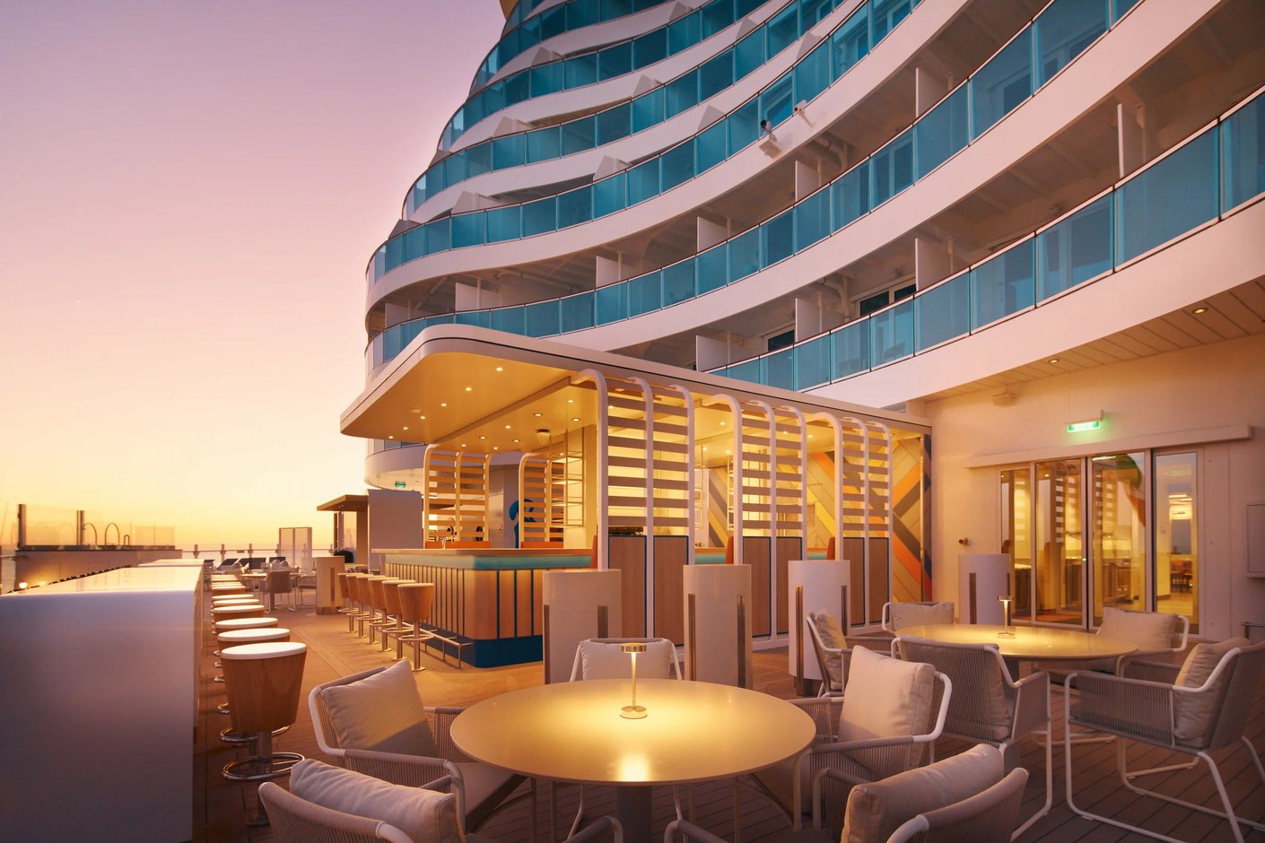 Salon extérieur sur navire de croisière au coucher du soleil avec tables et sièges