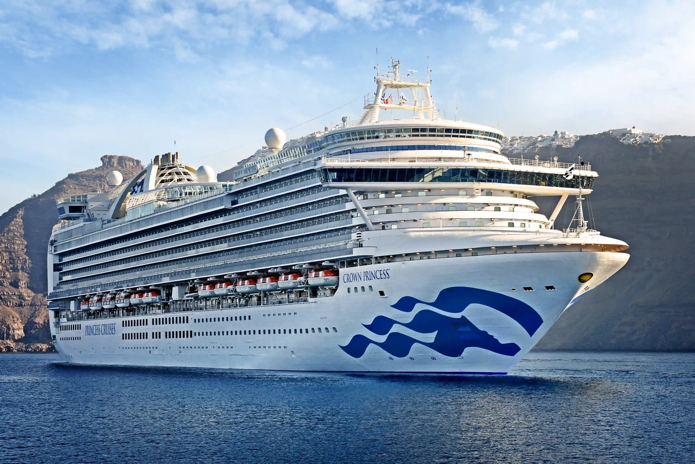 Grosses Kreuzfahrtschiff Crown Princess auf ruhigem Meer vor Kuestenlandschaft