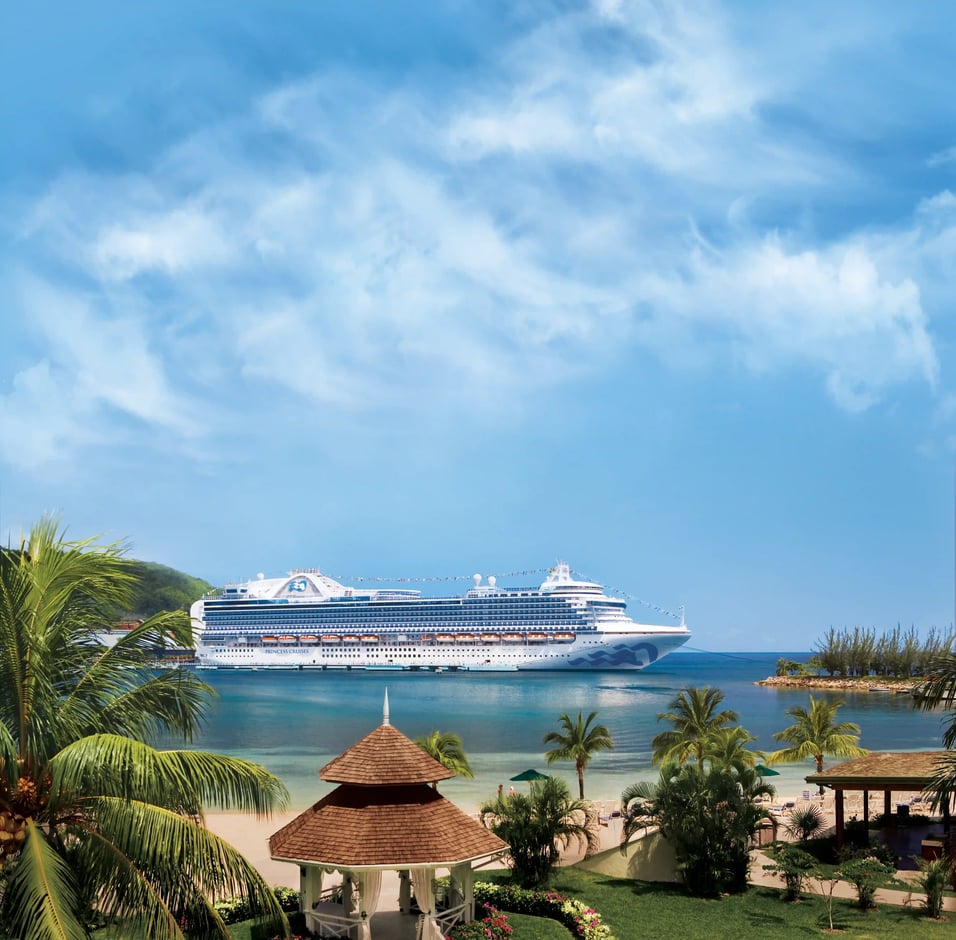 Crown Princess als modernes Kreuzfahrtschiff vor tropischer Insel und Strand