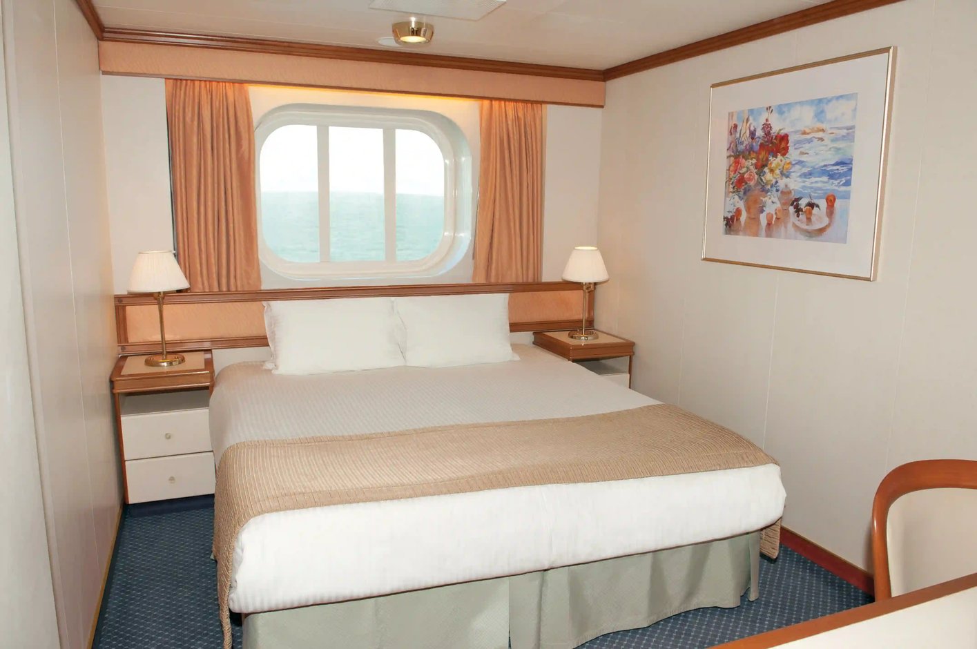 Aussenkabine mit Doppelbett, Nachttischen, Lampen und Fenster mit Meerblick