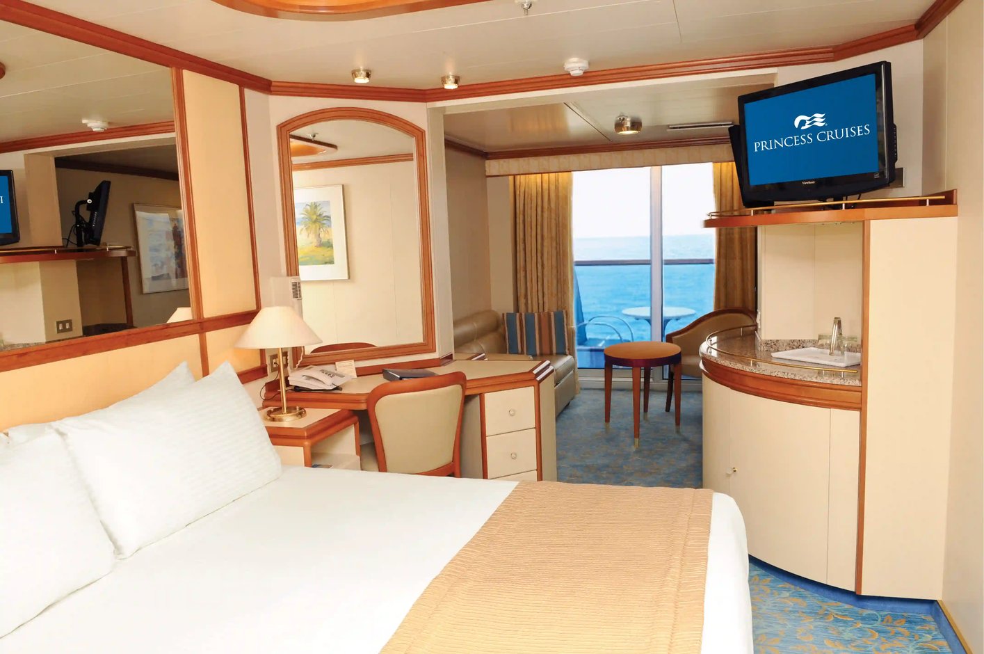 Balkonkabine mit Bett, Schreibtisch, Sitzbereich und Zugang zum Balkon