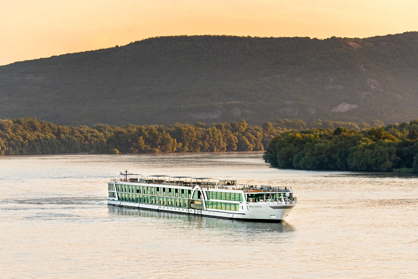 Flusskreuzfahrtschiff AMADEUS Amara auf der Donau vor bewaldeter Hügellandschaft