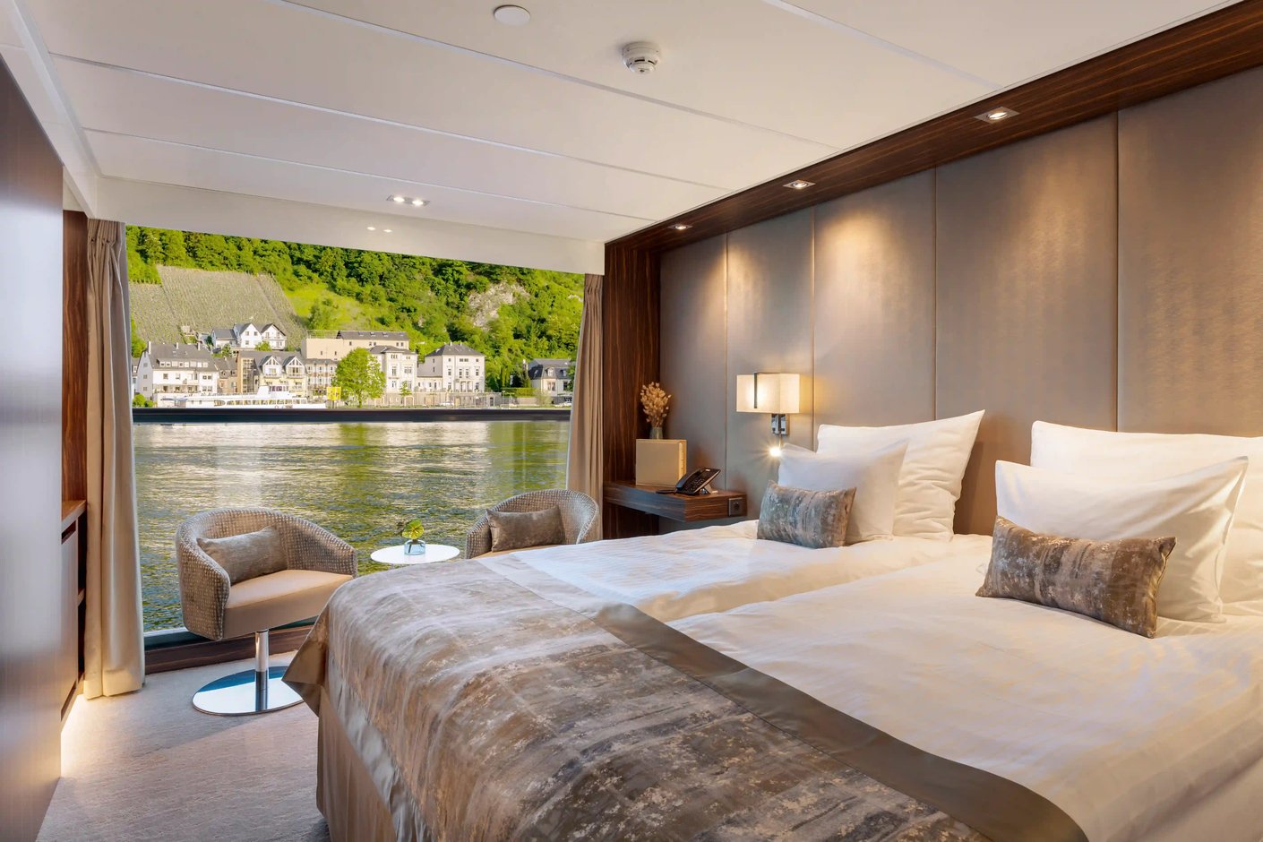 Komfortable Kabine mit Doppelbett, Sitzbereich und Panoramafenster mit Flussblick