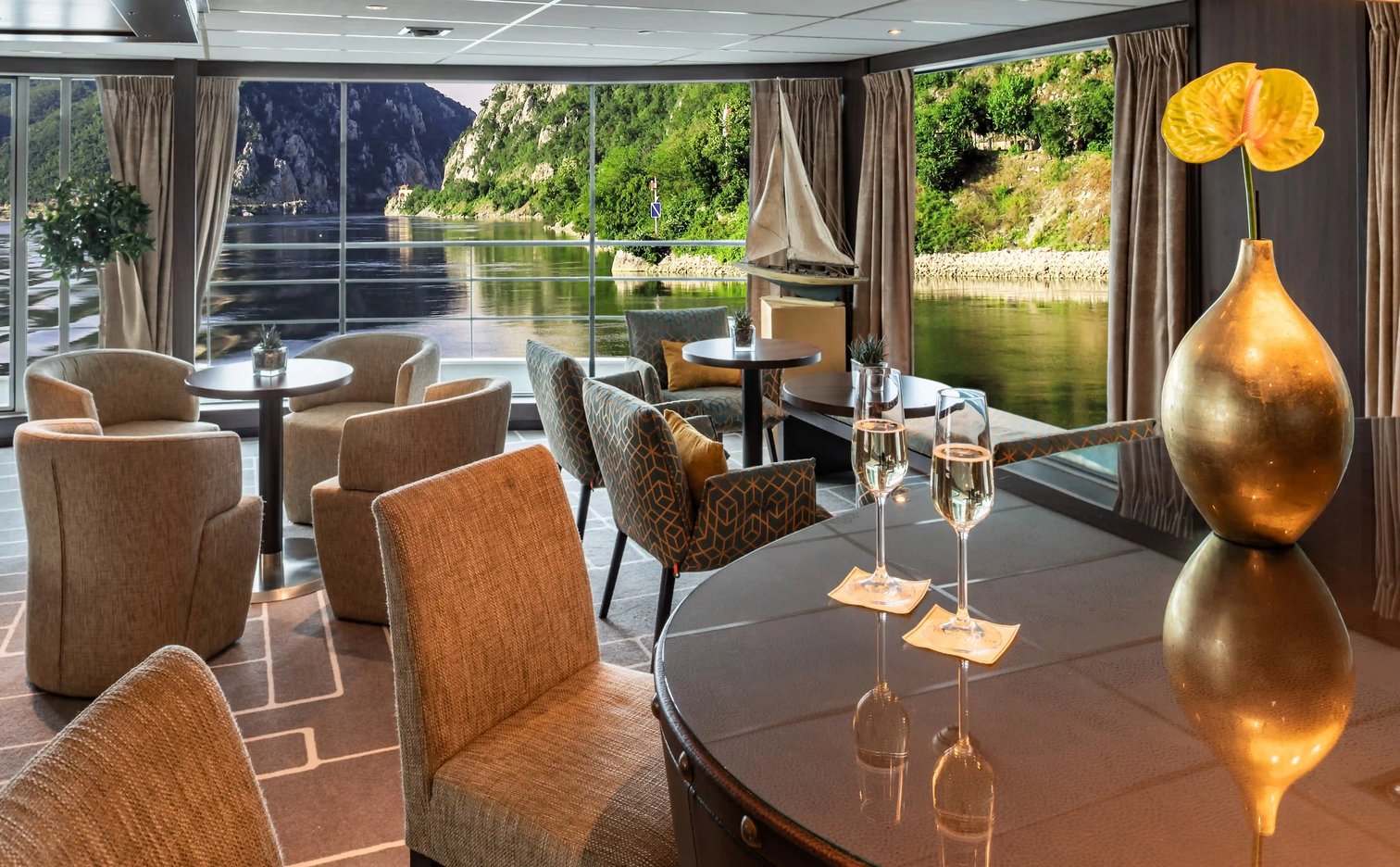 Panorama-Lounge mit Sitzgruppen und Blick auf den Fluss