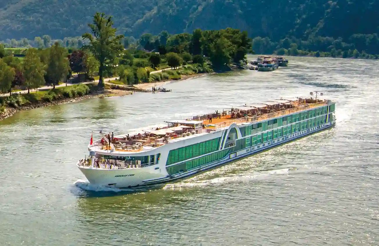 Flusskreuzfahrtschiff auf der Donau in grüner Flusslandschaft