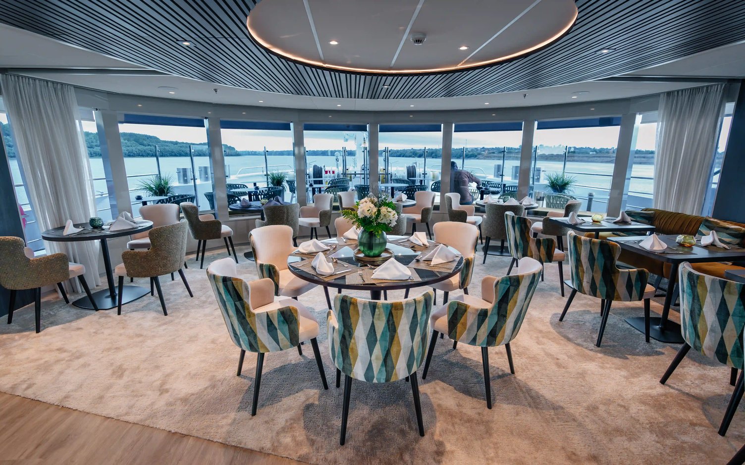 Panorama-Restaurant eines Flusskreuzfahrtschiffs mit gedeckten Tischen