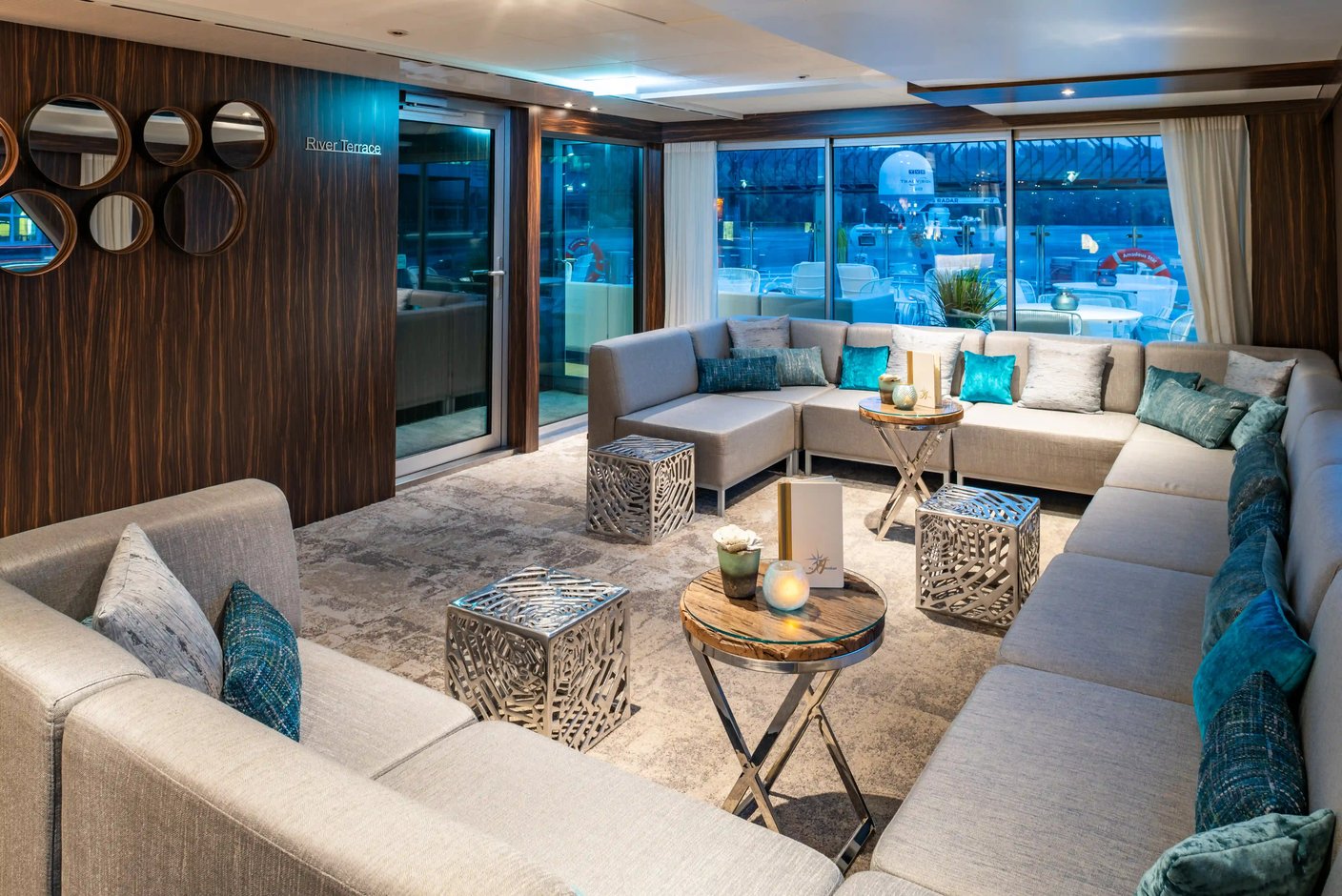 Gemütlicher Innenbereich der River Terrace mit komfortablen Sitzgruppen und Blick nach draussen