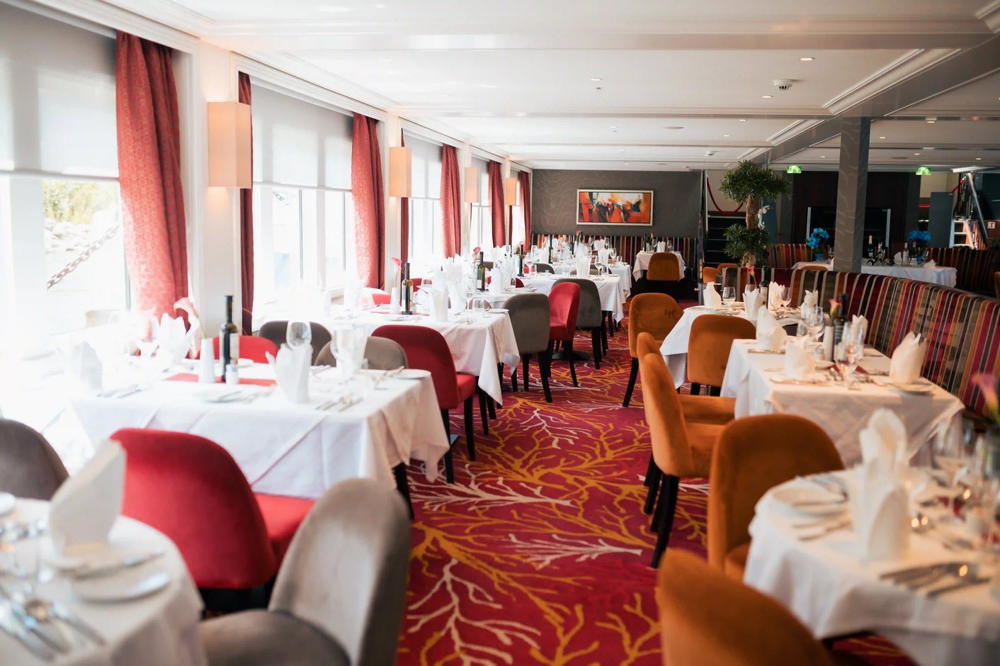 Restaurant panoramique du MS Charles Dickens avec tables élégamment dressées.