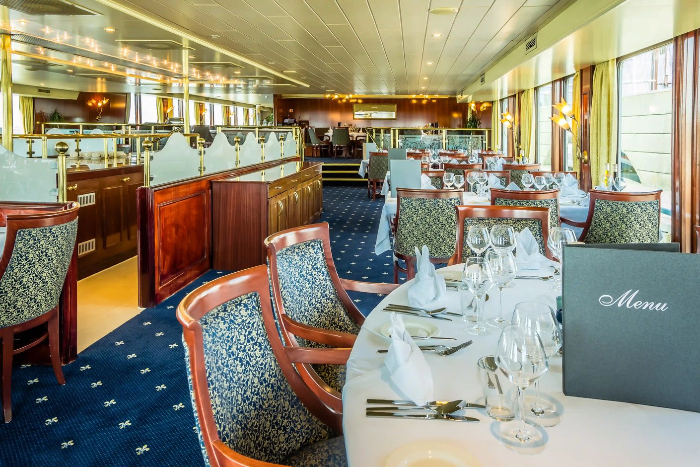 Restaurant avec tables dressées et grandes fenêtres panoramiques