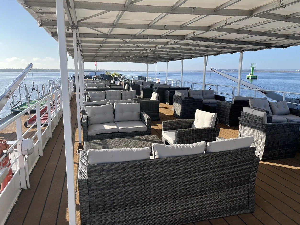 Großzügiges Sonnendeck mit Loungemöbeln und freiem Blick über Wasser und Küstenlandschaft