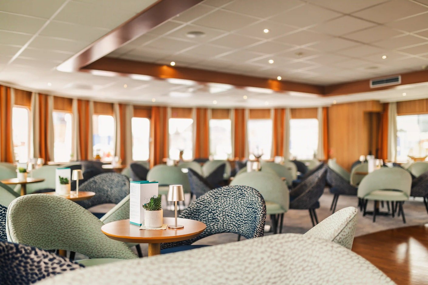 Elegante Panorama-Lounge mit Sesseln und Tischen für entspannte Stunden an Bord