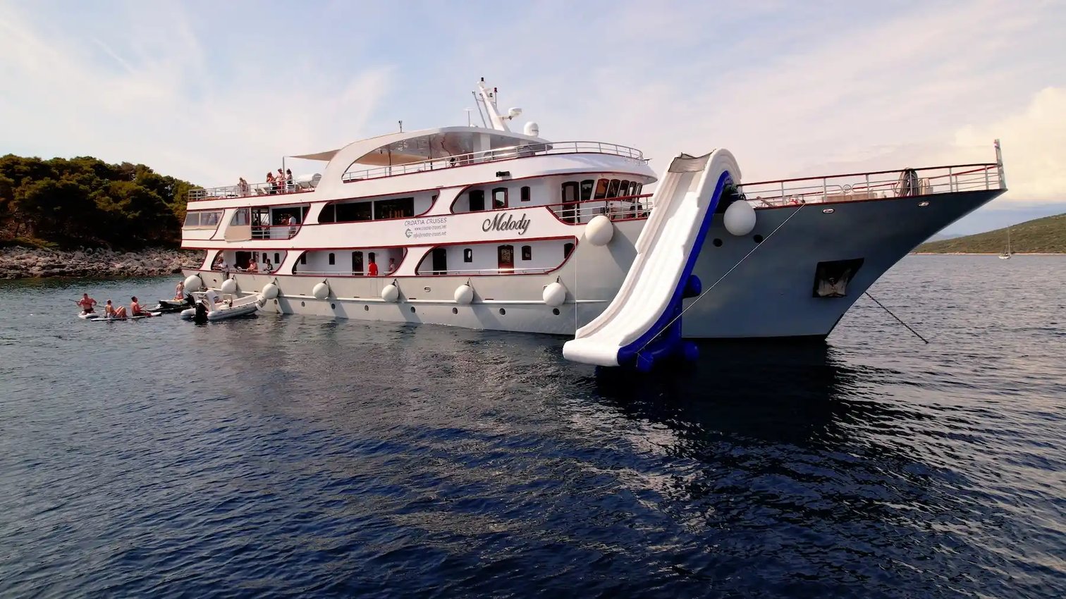 Kreuzfahrtschiff vor Anker mit Wasserrutsche und Badeplattform