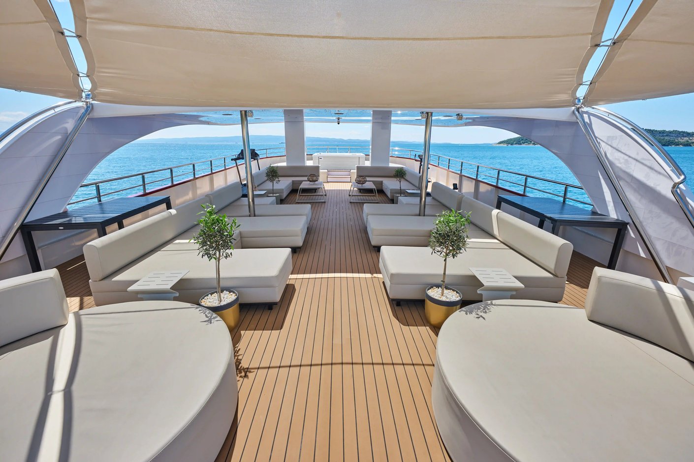 Sonnendeck eines Kreuzfahrtschiffes mit Lounge-Möbeln und Blick aufs Meer