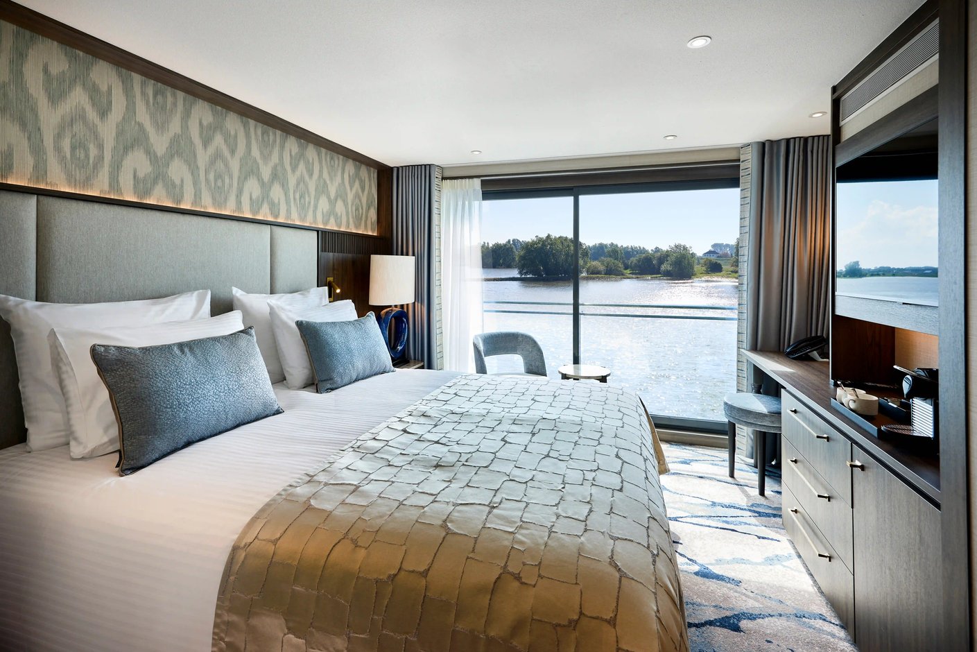 Komfortable Schiffskabine mit großem Bett, Sitzbereich, moderner Einrichtung und französischem Balkon mit Flussblick.