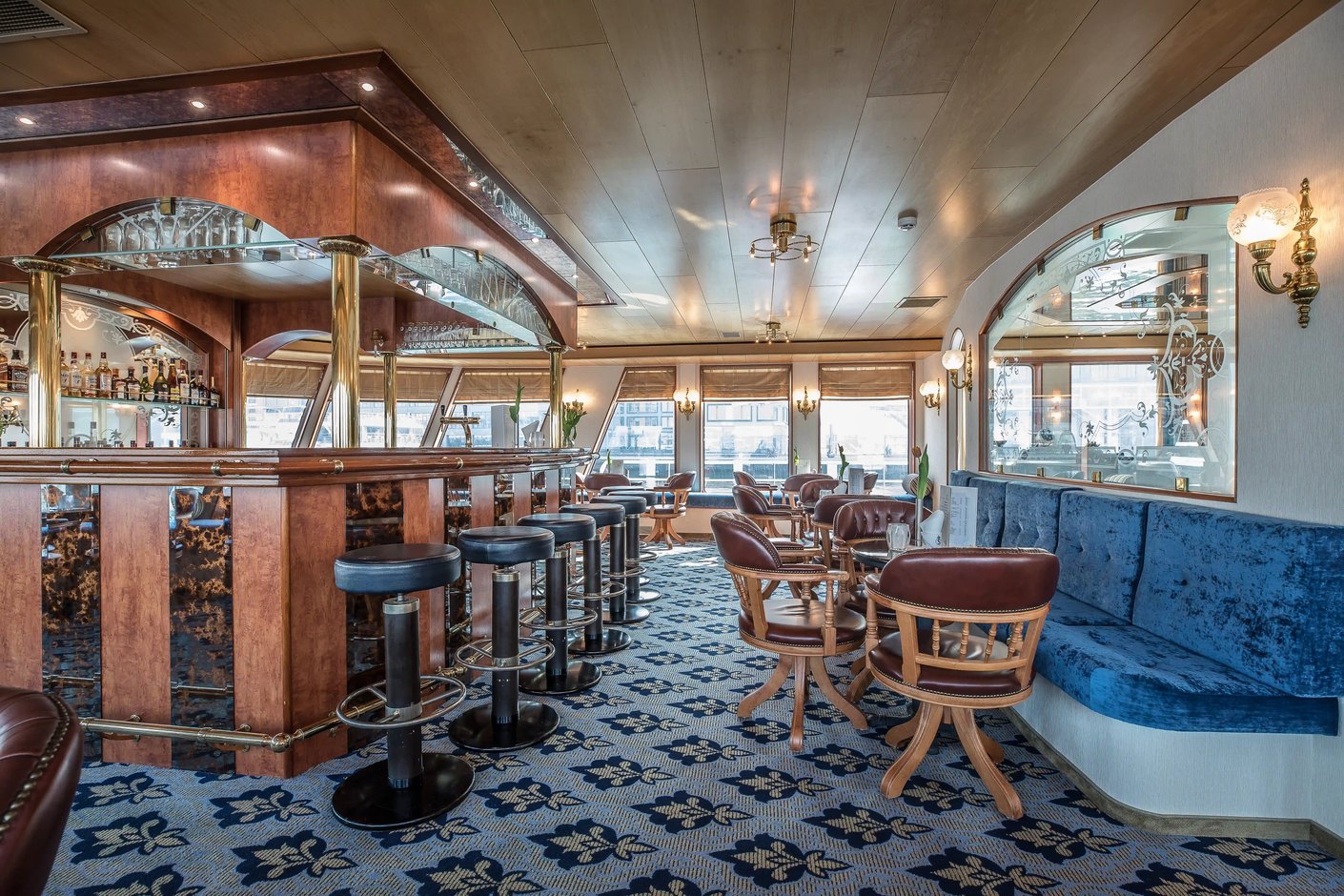 Eleganter Barbereich an Bord mit Barhockern, Sitzgruppen und grossen Fenstern