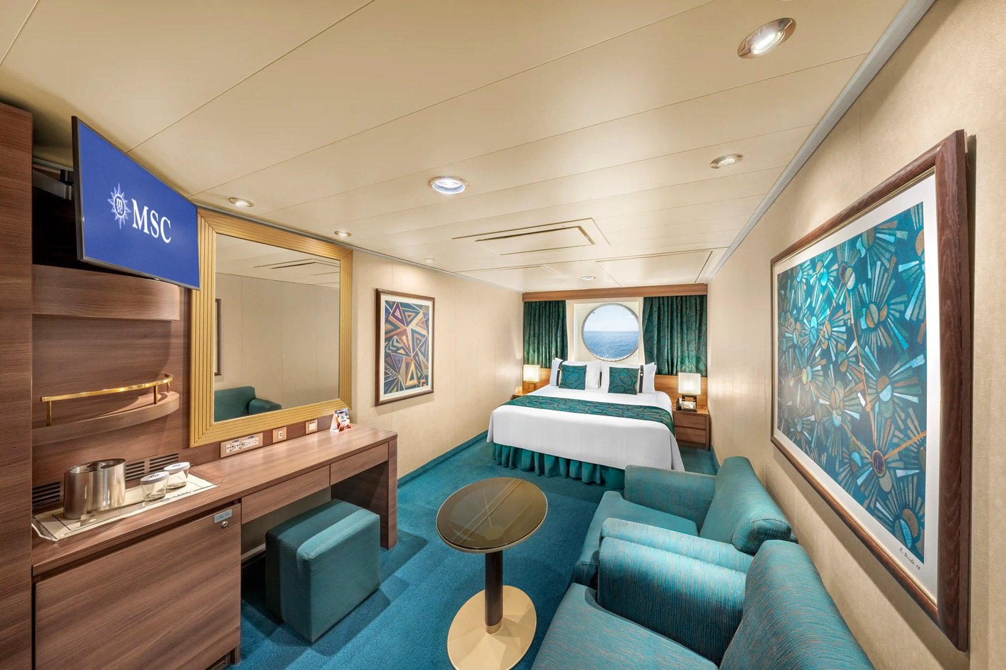 Aussenkabine auf der MSC Fantasia mit Doppelbett, Bullauge, Sofa und maritimem Farbkonzept.