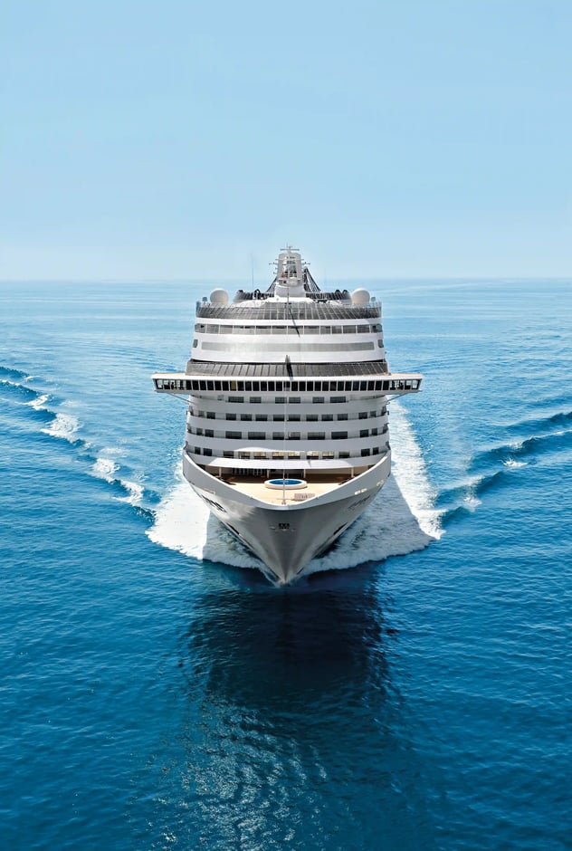 Frontale Ansicht des Bugs der MSC Fantasia während der Fahrt auf ruhigem, blauem Meer.