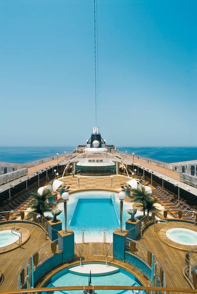 Grosszügiges Aussendeck der MSC Musica mit Pool, Sonnenliegen und Blick auf das offene Meer.