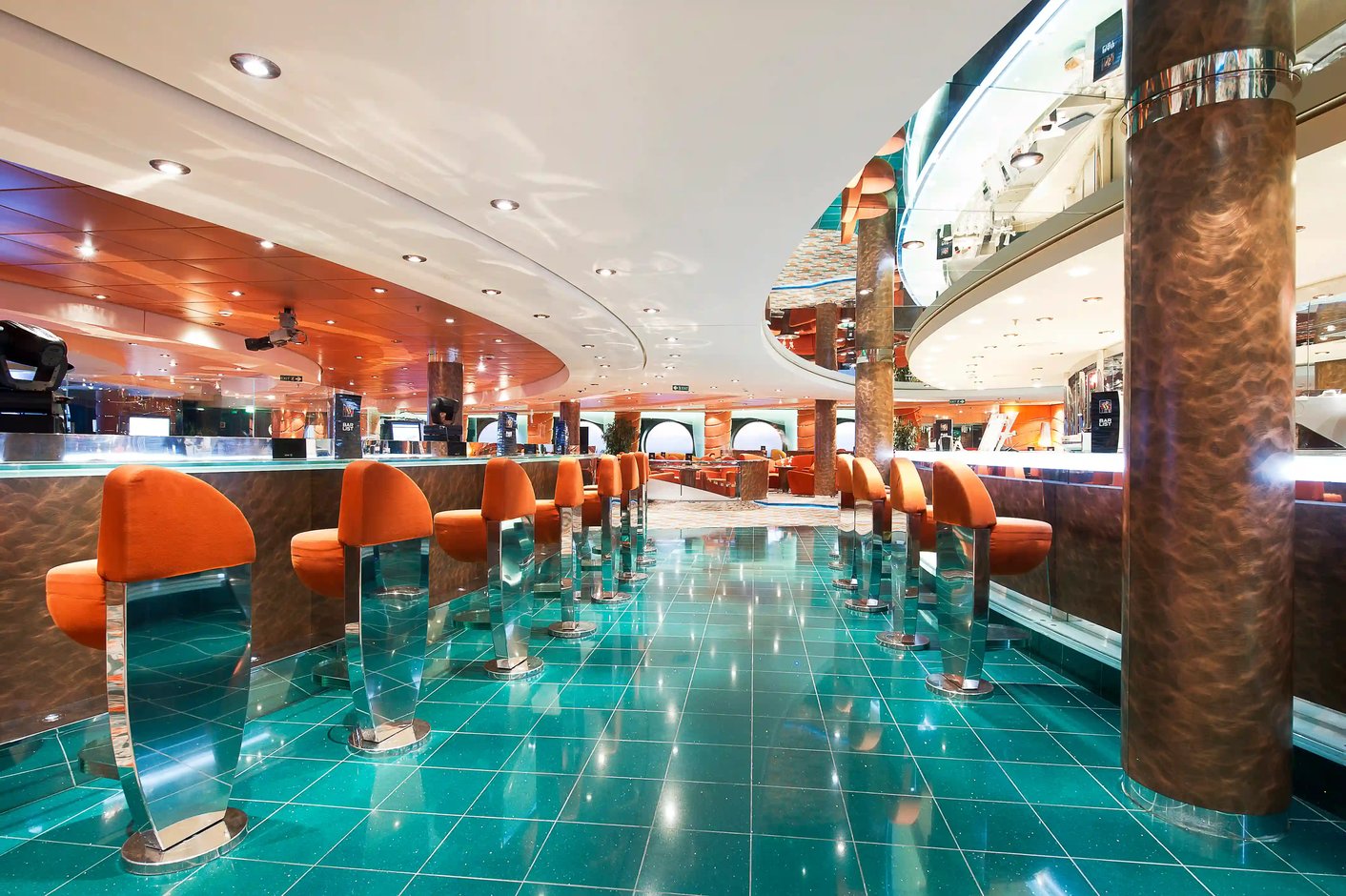 Elegante Bar auf der MSC Musica mit Barhockern, glänzender Theke und stimmungsvoller Beleuchtung.