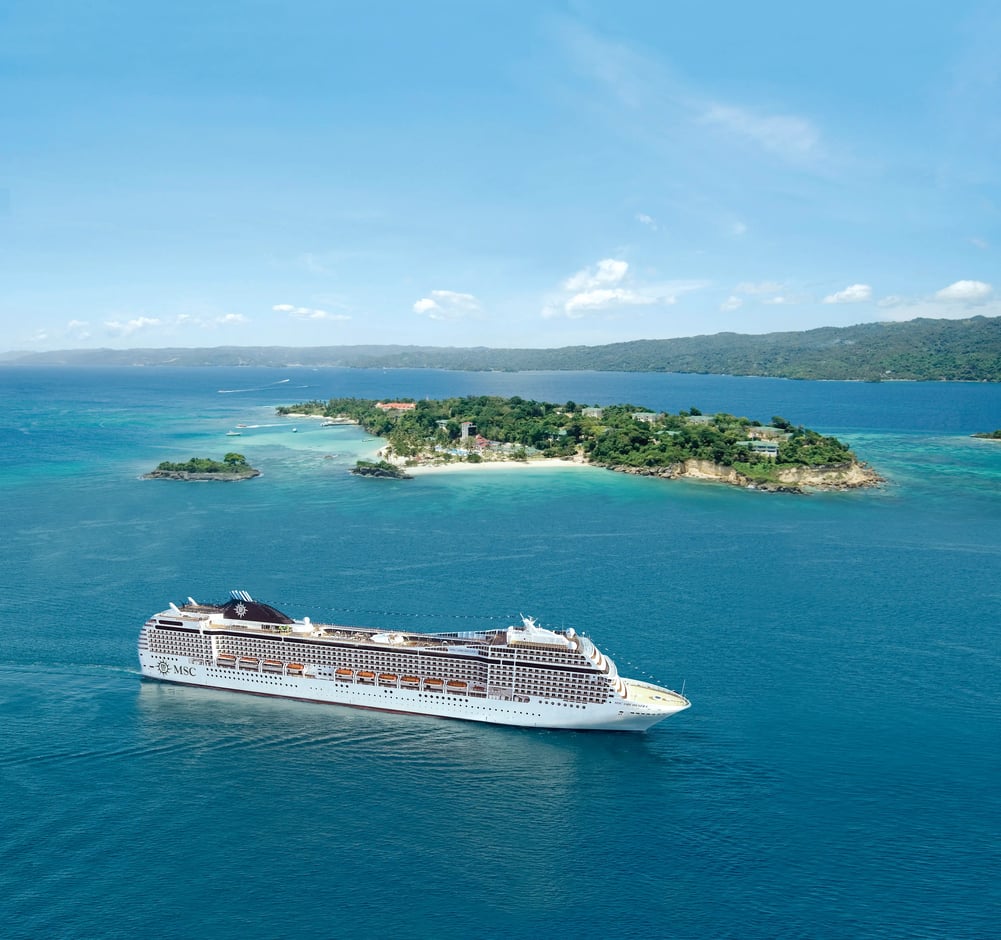 Navire de croisière naviguant sur une mer turquoise près d une île verdoyante