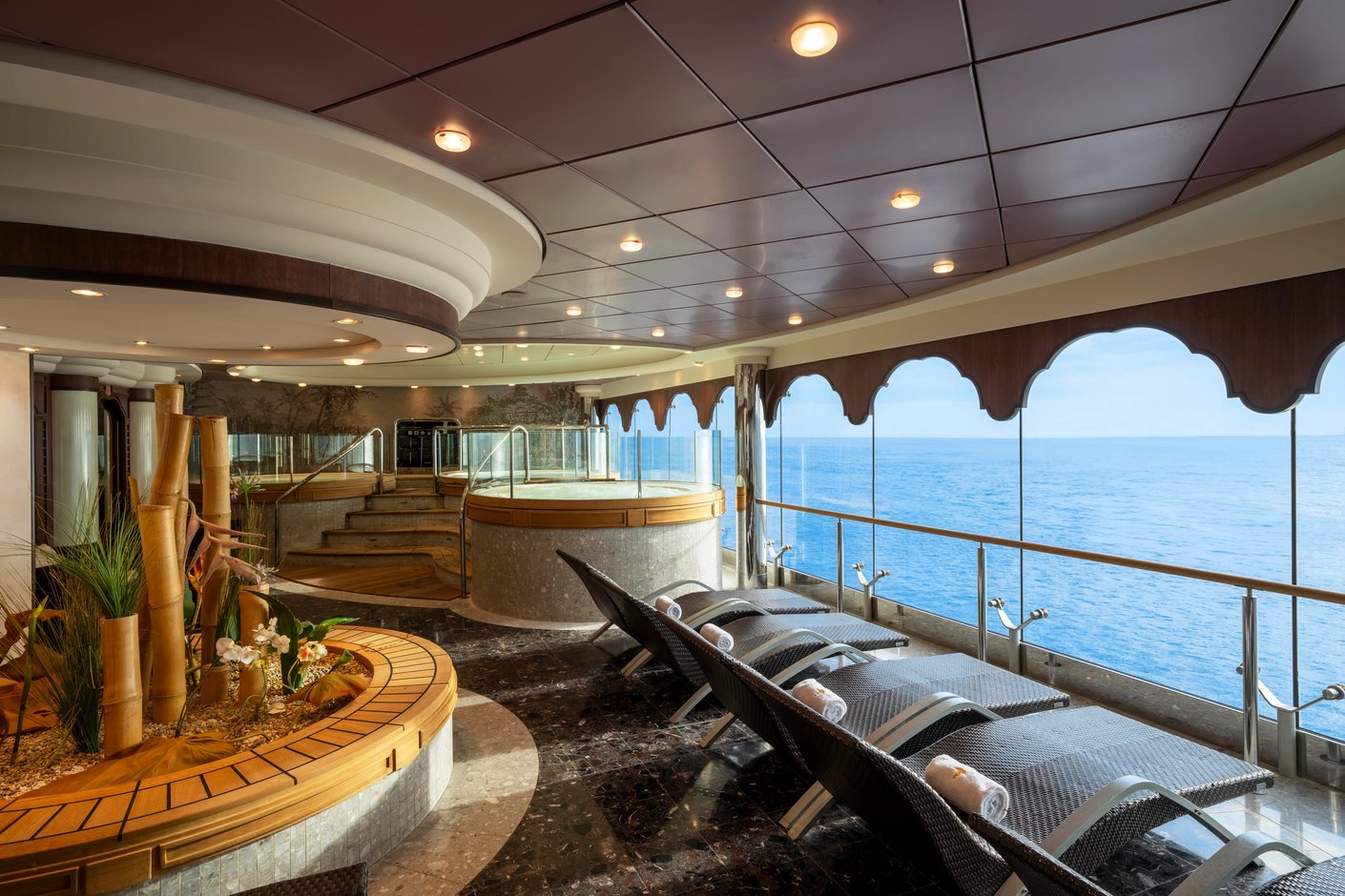 Espace bien être avec chaises longues, jacuzzi et vue panoramique sur la mer