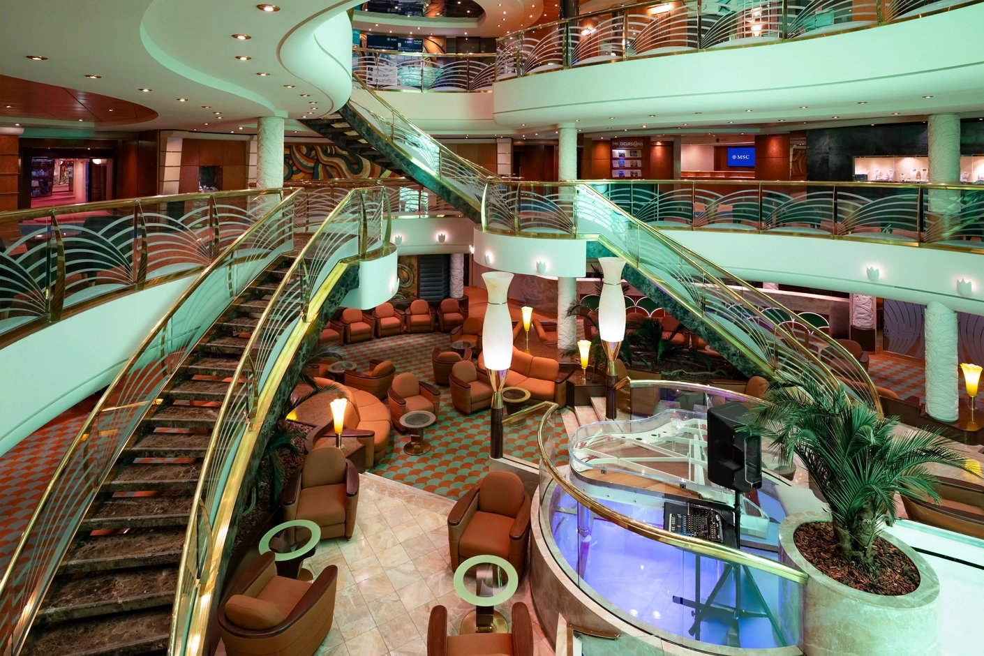 Grosszügiges Atrium auf der MSC Poesia mit geschwungenen Treppen, Sitzbereichen und mehreren offenen Decks FR: