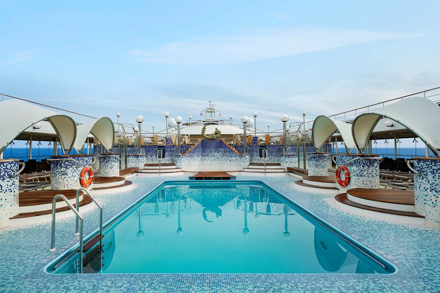 Aussenpool auf der MSC Poesia mit Liegebereichen, Mosaikfliesen und Blick auf das offene Meer