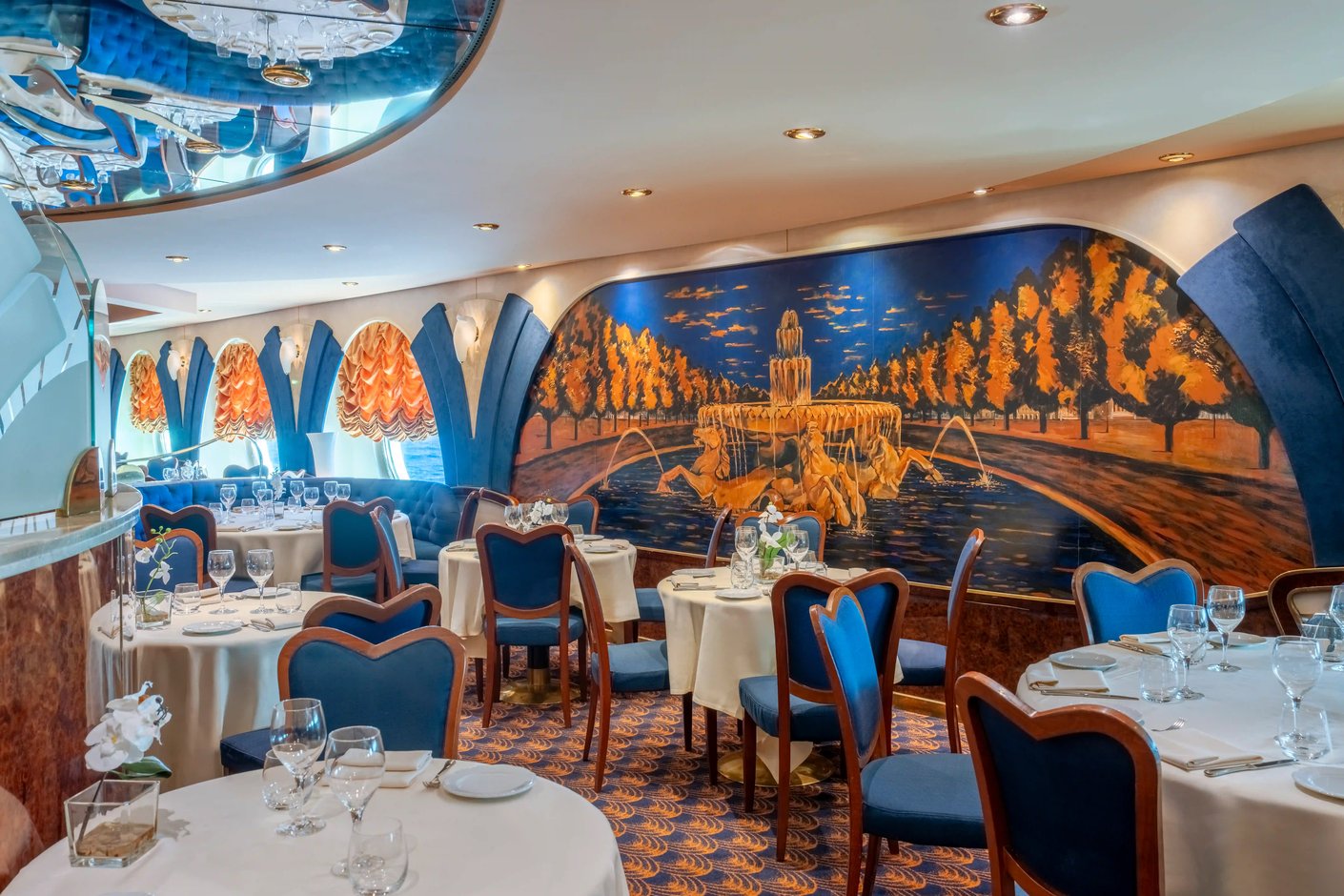 Elegantes Restaurant auf der MSC Poesia mit gedeckten Tischen, blauen Stühlen und dekorativer Wandgestaltung