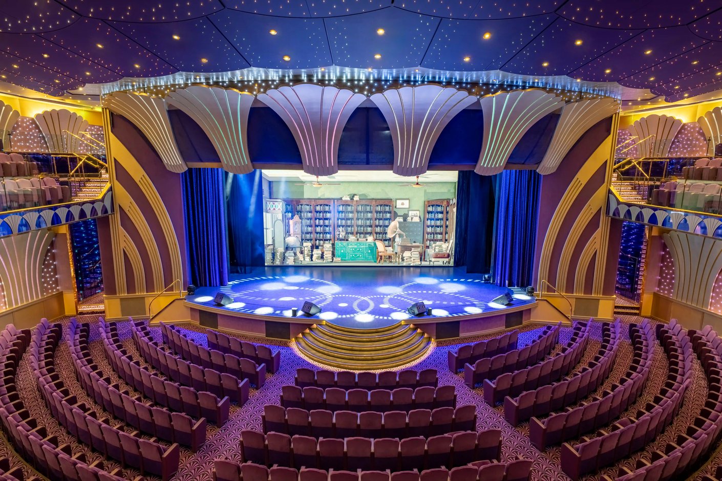Grosses Theater auf der MSC Poesia mit Bühne, Sitzreihen, dekorativer Decke und stimmungsvoller Beleuchtung