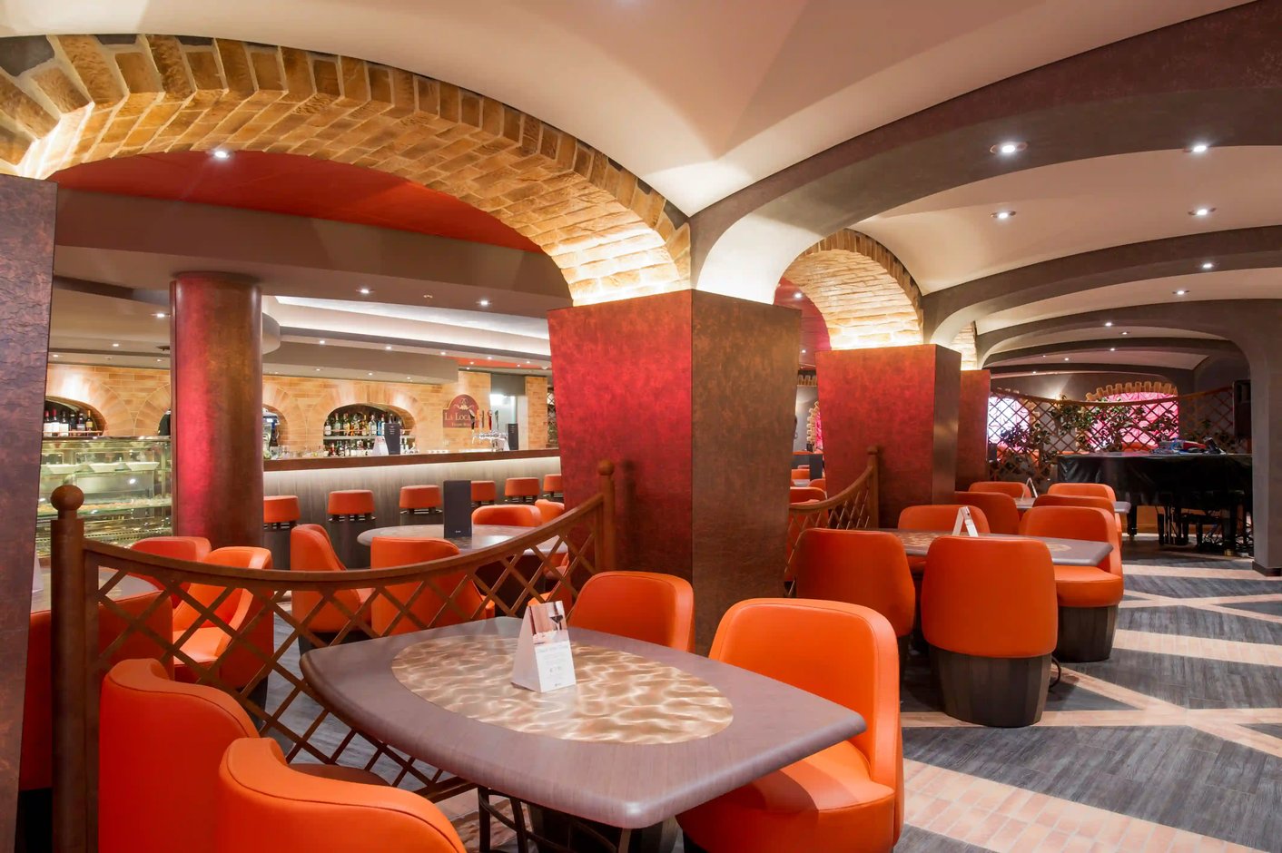 Gemütliche Bar an Bord der MSC Preziosa mit Sitzgruppen, Theke und warmem Licht