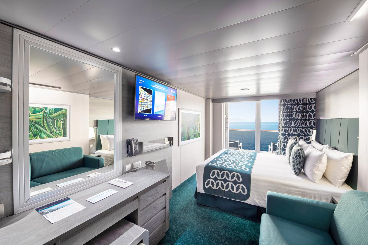 Balkonkabine auf der MSC Virtuosa mit Doppelbett, Schreibtisch, Sitzmöbeln und Zugang zum Balkon