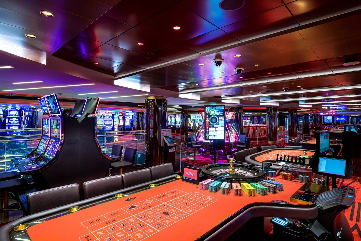 Casino auf der MSC Virtuosa mit Spieltischen, Spielautomaten und farbiger Beleuchtung
