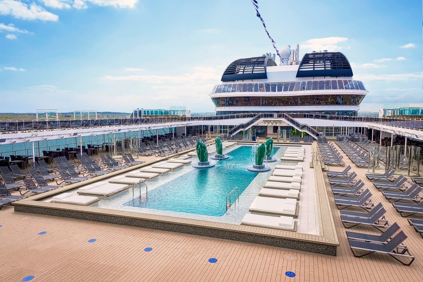 Grosszügiger Aussenpool auf der MSC Virtuosa mit Liegestühlen, Wasserfontaenen und Sonnendeck