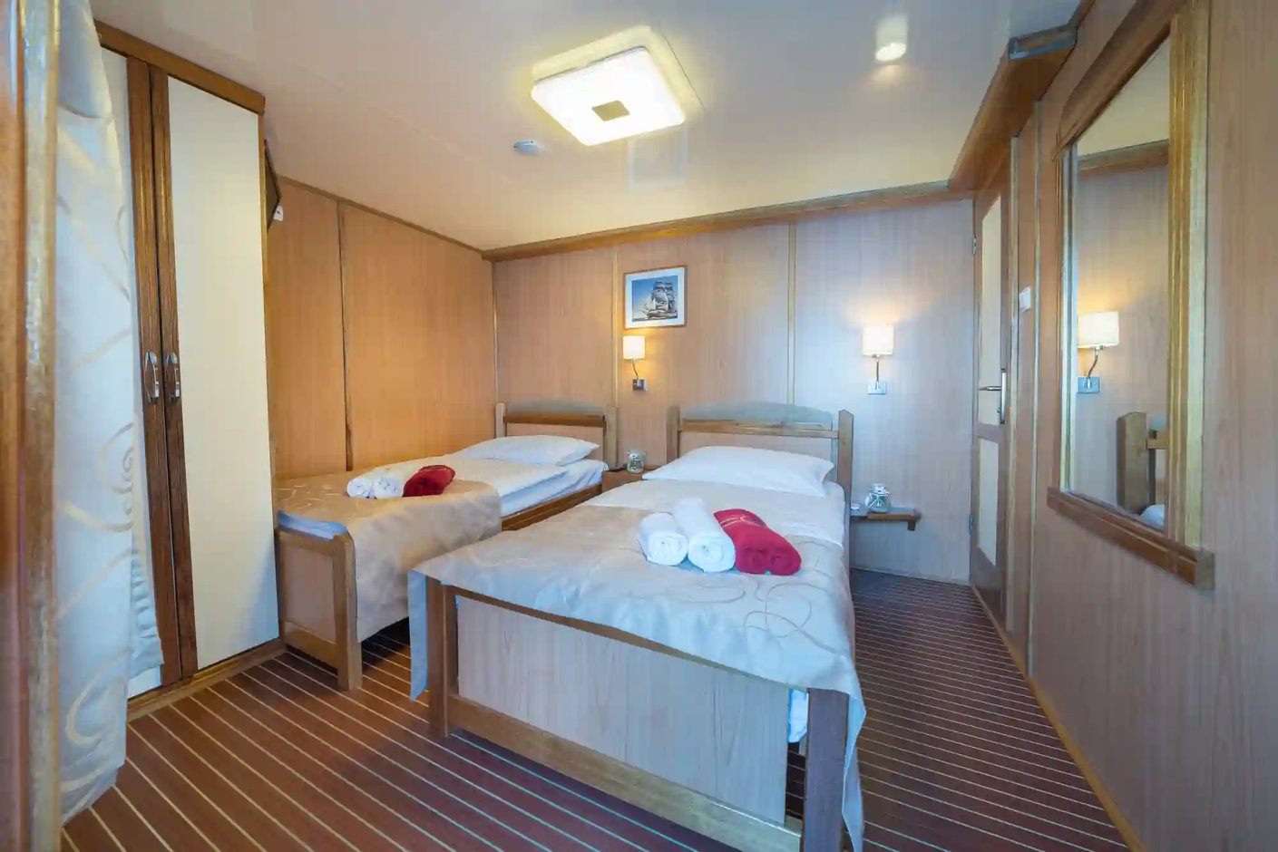 Cabine d’un navire de croisière avec deux lits simples et interieur en bois