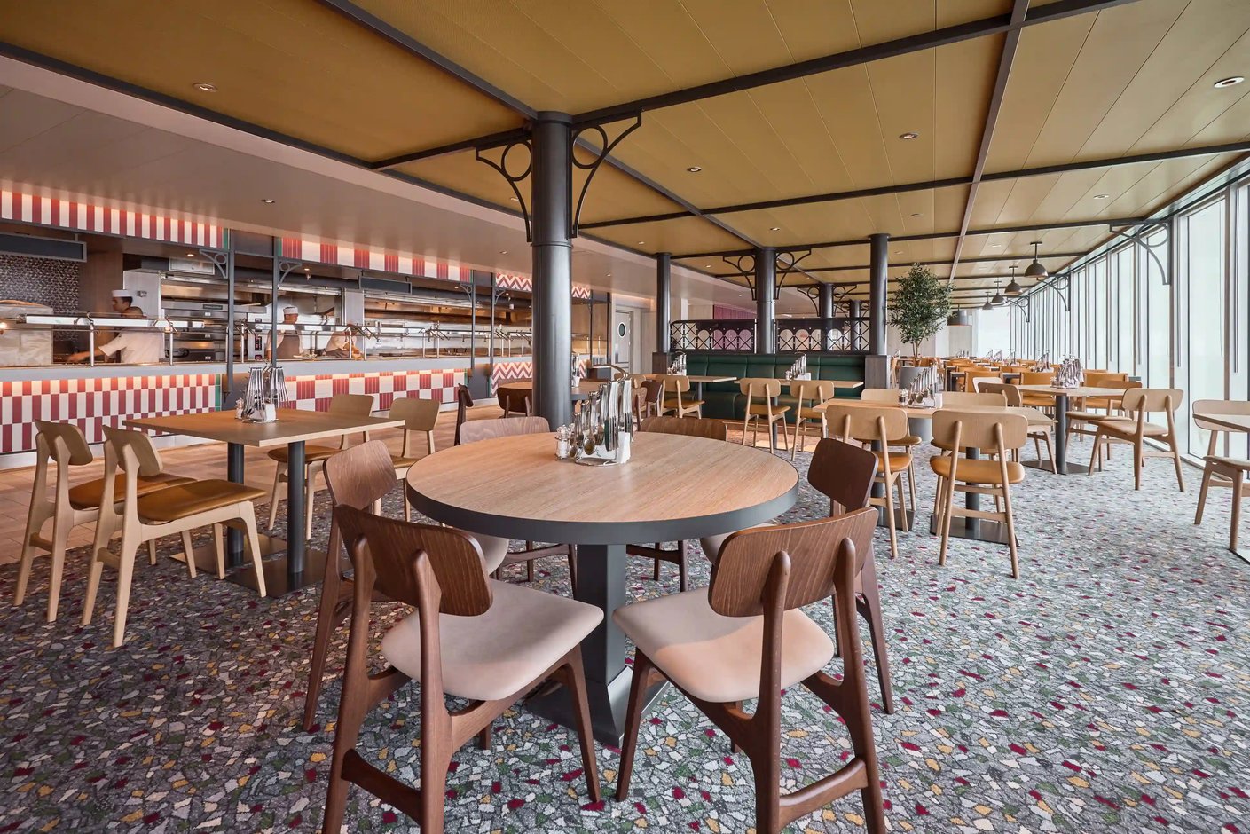 Restaurant mit offenen Sitzplätzen, runden Tischen und offener Küche